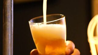 Bartender serving beer from a tap looking down at his hands