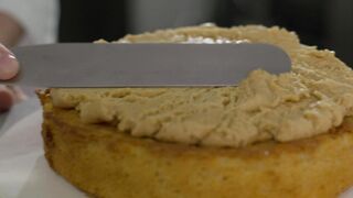 Pastry chef putting the filling on a cake