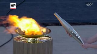 Greece hands over Olympic flame to Paris 2024 organizers in Athens.