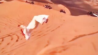 Arab man effortlessly backflips down the dunes