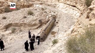 Jewish Ultra-Orthodox families inspect debris of what's believed to be an intercepted Iranian surfac.