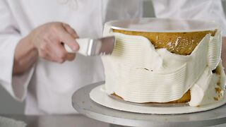 Expert pastry chef covering a cake with icing