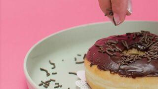 Spreading Chocolate Chunks on a Glazed Donut