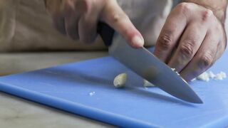 Chef skillfully chopping garlic