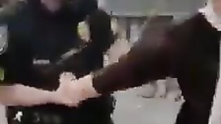 A child is being handcuffed in front of his mother and the child is crying