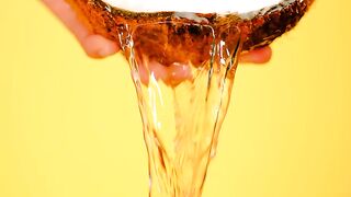 Spilling water from a coconut on a yellow background