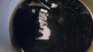 Mixing coffee in a cup seen up close