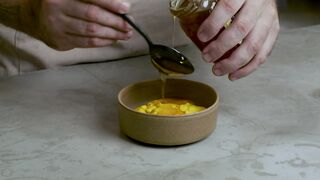 Pastry chef adding honey to a mixture