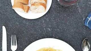 Placing a plate of spaghetti bolognese on a table