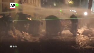 Georgian police use water cannons to try to disperse Tbilisi protesters.
