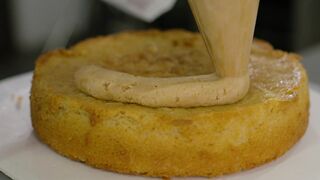 Pastry chef adding filling in the preparation of a cake