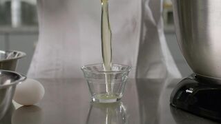 Close up shot of a pastry chef adding egg to a mixer