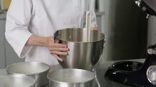 Pastry chef distributing a mixture in baking molds