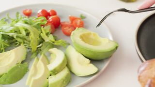 Preparing a slice of bread with avocado and vegetables