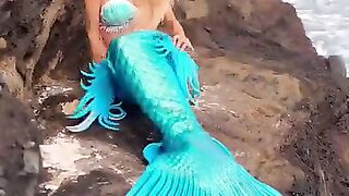The girl is dying on the stone as a fish