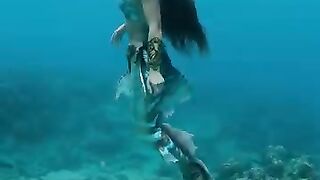 The girl is swimming in the sea with the body of a fish