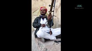 A man playing a traditional musical instrument of india
