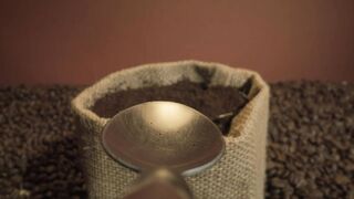 Point of view of a spoon grabbing coffee from a sack