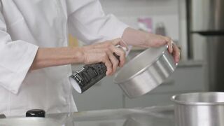 Pastry chef oiling baking pans