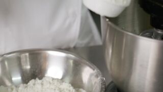 Pastry chef adding ingredients to a blender