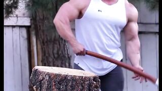 A bodybuilder is chopping wood.