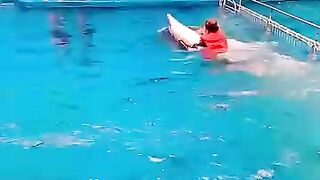 This girl is sitting on a fish and swimming