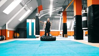 Bodybuilder flips a tire on the floor over and over - adalinetv
