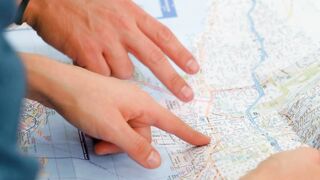 Pointing to a map of a city with his hands - adalinetv