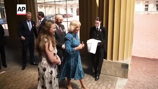 UK's Queen Camilla feeds animals at Buckingham Palace charity reception.