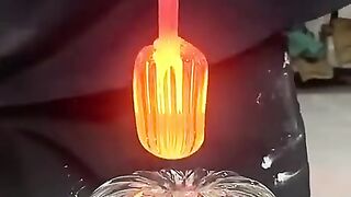 Glass blower applies the final touch to a glass pumpkin