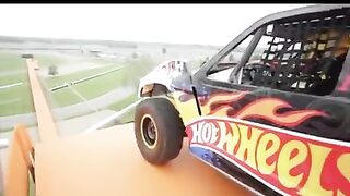 Driver, Tanner Foust, drops down 90 feet of orange track and soars 332 feet through the air.