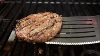 Flipping a burger on a BBQ