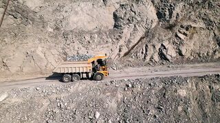 Large truck carrying a load of rubble up a mining site