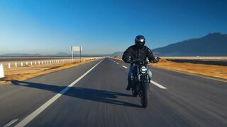 Man traveling by motorcycle on an empty road