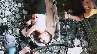Displaced Palestinian siblings comfort toddler sister in a makeshift cradle