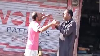 Two men with knives in their mouths, balance them on the tip...