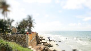 Tilt shift of people walking on windy beach