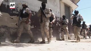 Armed Haitian police surround University hospital before Prime Minister's visit.