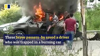 Passers-by save driver trapped in burning car in China.