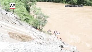 Rescuers in Nepal search for two buses swept into river with more than 50 people on board.