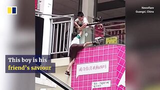Boy keeps friend from falling from escalator in China.