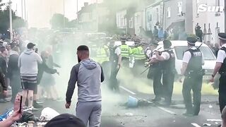 Crowds clash with cops & set police van on fire outside mosque near scene of Southport stabbings.