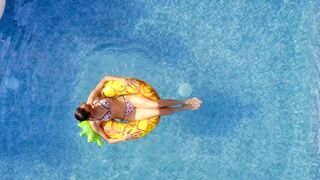 A young woman seen from above on a pineapple.
