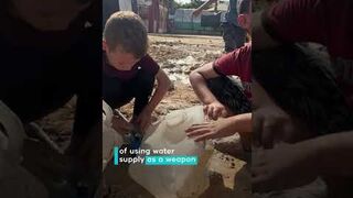 Displaced children in Gaza fill containers with contaminated water from leaking pipes