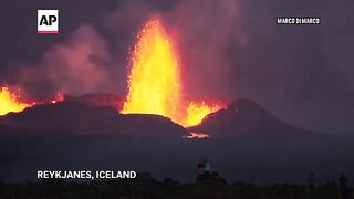 Northern lights shine in night sky as lava spews from erupting volcano in Iceland