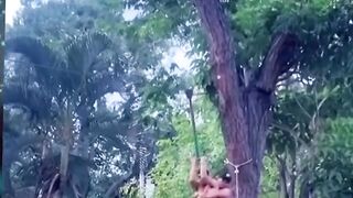 funny action of 2 people hanging from a rope above the pool