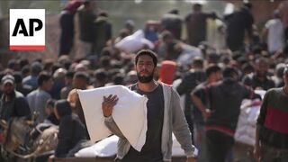 Displaced Palestinians desperate for aid gather at UNRWA warehouse in Gaza