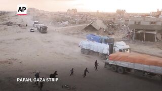 Palestinians in Gaza take supplies from aid trucks in Rafah.
