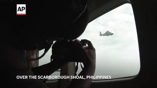 Chinese navy helicopter flies close to Philippine patrol plane over disputed shoal.