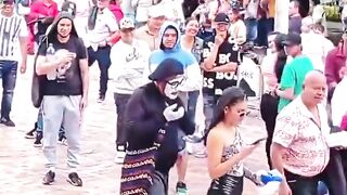 il imite la démarche des passants avec un air drôle